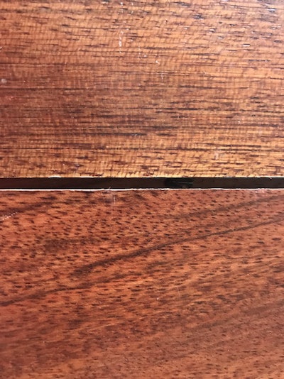 A Brazilian cherry wood floor showing gaps between boards.