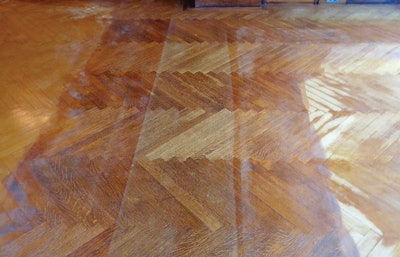 The condition of dining room floor shows original finish on left side next to stains/finishes added within the last 30 years.