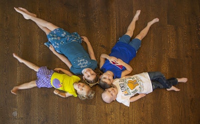 The Walsh's children on the family's new hardwood floor.