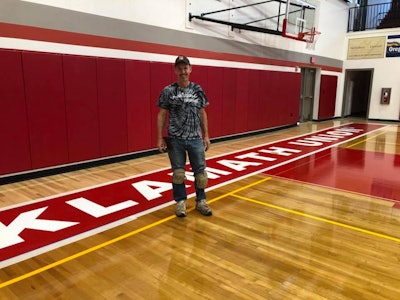Steve Hightower of A-Game Courts pictured after amending a spelling error on the Klamath Union High School basketball court. Source: Klamath Union High School Facebook