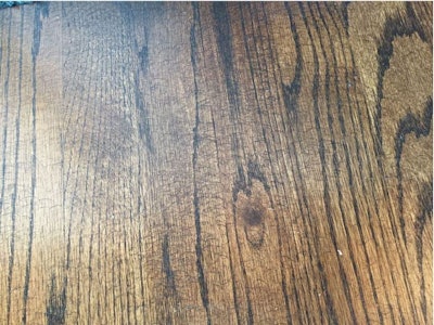 Sanding marks from a hand-held random orbital sander were obvious on this wood floor once stain was applied.