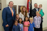 U.S. Rep. Jason Smith (left) stands with the Cobb family after Rachel and Sam were recognized for their charity work with adoption agencies.