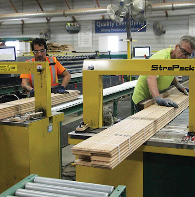 (10) Workers use the strapping machine for bundles of flooring.