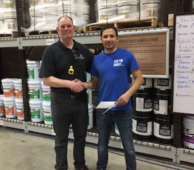 Left to Right: Mike Glavin presents the $500 “Fastest Nailer in the East” prize to Ricardo Silva of RM Floors.
