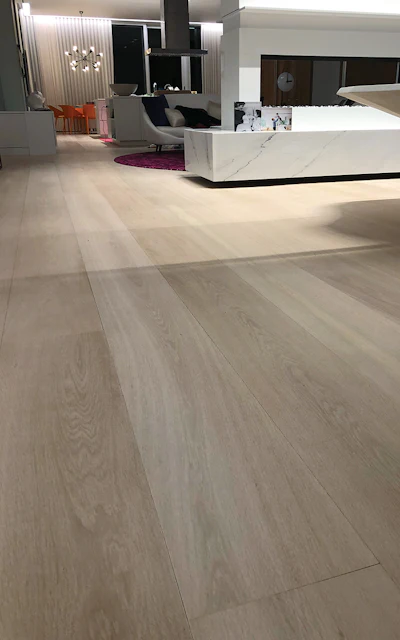 Once we had the color corrected throughout the floor, we noticed a very short rift and quartersawn board right in the middle of the floor, so Vartan carved and used our graining technique to make the board blend in with the adjacent livesawn boards (top photo). The board is in the photo above but is not noticeable because the repair blends in seamlessly.