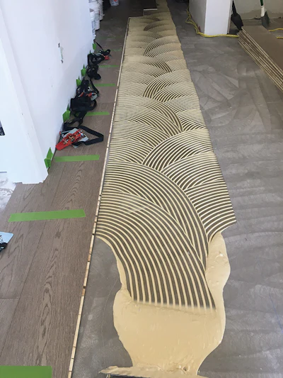 Taping wedges between the flooring and the wall gives me something to push up against as I'm installing.