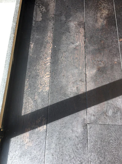 When the job was close to complete, we had to sand and stain several areas of the floors again after windows and doors that weren't sealed were pressure-washed from the outside. The water and cleaning solution used in the pressure cleaner removed the colored oil and PreTone from the oak, as you can see here.