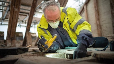 Archaeologist Matt Champion looks beneath the floorboards in the attic of the manor. National Trust Photo
