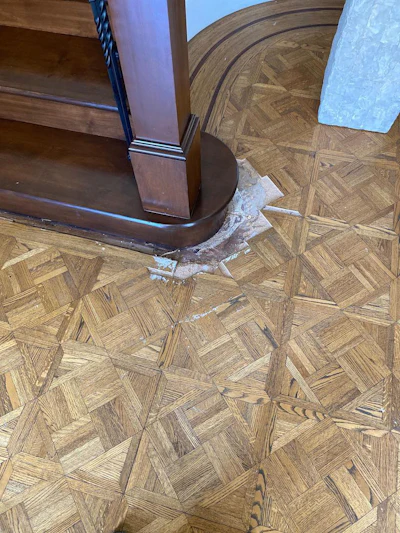 The original installers of this floor didn't continue the border in front of the stairway. The Wood Floor Guys decided to fix that.