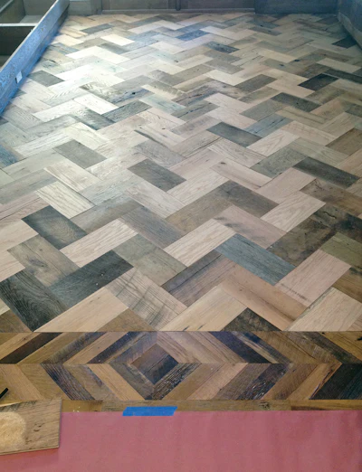 The dining room herringbone floor, pictured here during installation, was one of the non-traditional floors Angelica Henry Design planned to add pizazz to the home.