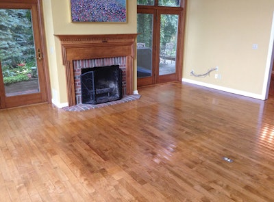 (Before) This is a 20-year-old maple floor that discolored over time because of the UV-sensitive finish used. It also was very cupped and required that I sand it at about 35-degree angle on the first cut. Sanding it very fine was important, because I stained the floor a nutmeg color.