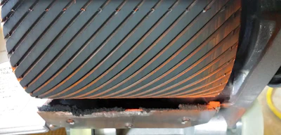 The owner of this machine said his drum was cutting flat, but the service tech said he could tell otherwise just by looking at the abrasive. They sprayed the drum orange and began to dress it, which showed an obvious unevenness.