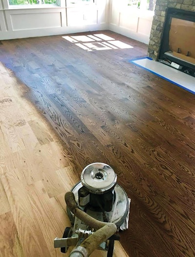Jason Bennett of Natureâs Flooring Group in Charlotte, N.C., is a pro who always buffs on stains. âI used to mop on and wipe off stain with rags, but buffing it on uses A LOT less stain, and tons of stain doesnât end up in the cracks and seams of the floor, which can cause bleedback,â he says. âWe pour a little stain in the center of a carpet and buff it on until we see that it needs more. Then we take a clean carpet and clean up excess stain. I like to use a rag under the cleanup carpet.â On this job Bennett is staining 5-inch red oak with DuraSealâs Dark Walnut stain.