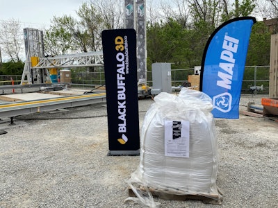 At the groundbreaking ceremony in Virginia, Alquist 3D banners mark the Black Buffalo 3D NEXCON printer, while the super-sack of Planitop 3D sits in front of the MAPEI Corporation banner.
