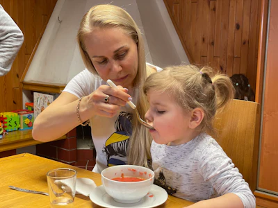 Olga (left), a refugee from Odessa, Ukraine, joined Nantucket Cares and helped to translate during the mission. She is pictured feeding Sasha, a refuge at a refugee camp in Siedlce, Poland.