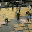 Arena staff reassemble the court after the baseline was discovered to be crooked prior to tipoff.