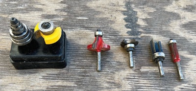 From left to right: An offset flush trim pattern bit, round over bit, top-bearing groove bit, pattern trim bit with top bearing and flush trim bit.