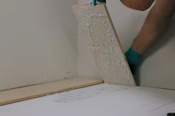 Periodically lifting boards after installation helps ensure proper slab coverage and transfer to the back of the flooring.