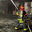 Firefighter sprays hose on house fire in Parma, Ohio.