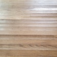 Using the wrong products can allow excess moisture to affect the wood flooring—cupping (shown here) is just one potential problem.