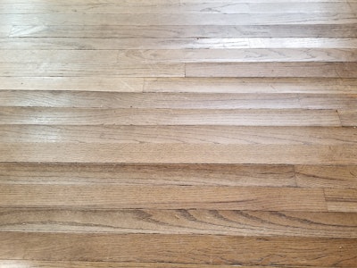 Using the wrong products can allow excess moisture to affect the wood flooring—cupping (shown here) is just one potential problem.