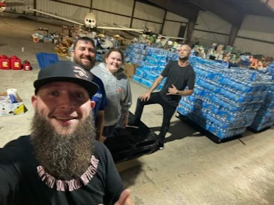 Kristopher Jeter, right, and other volunteers collect pallets of water to deliver to Hurricane Helene victims.