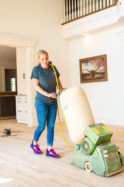 Hall started on the drum sander her first day as a wood floor sander.