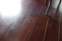 Wood floor “polishes” sold at box stores can often leave wood floors looking like this, and they must be removed before recoating.