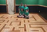 Jerokee Flooring owner Jeremy Partridge, his wife Jackie and their kids Noah (left) and Nick (right) sit in their Pac-Man-inspired game room.