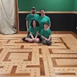 Jerokee Flooring owner Jeremy Partridge, his wife Jackie and their kids Noah (left) and Nick (right) sit in their Pac-Man-inspired game room.