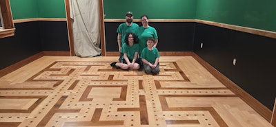 Jerokee Flooring owner Jeremy Partridge, his wife Jackie and their kids Noah (left) and Nick (right) sit in their Pac-Man-inspired game room.