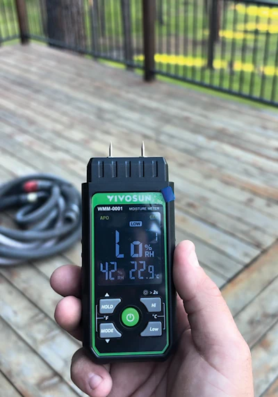 I take multiple moisture readings on top, between and underneath boards before I start the job and through the job. I use a moisture meter that shows the moisture content percentage (top photo, showing a super-dry deck) and I also use my moisture meter that reads high/low but also reads temperature and humidity, which is extremely important when doing decks.