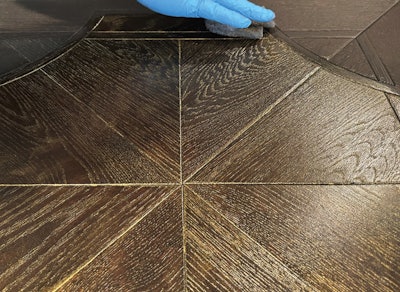 On this floor, you can see the plain background color around the perimeter and then the ceruse effect of gold mica dust in the next coat that remains in the open grain.