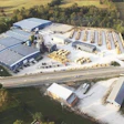 Aerial view of industrial complex with warehouse buildings near highway and farmland