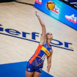 Female volleyball player jumping to spike ball during professional match