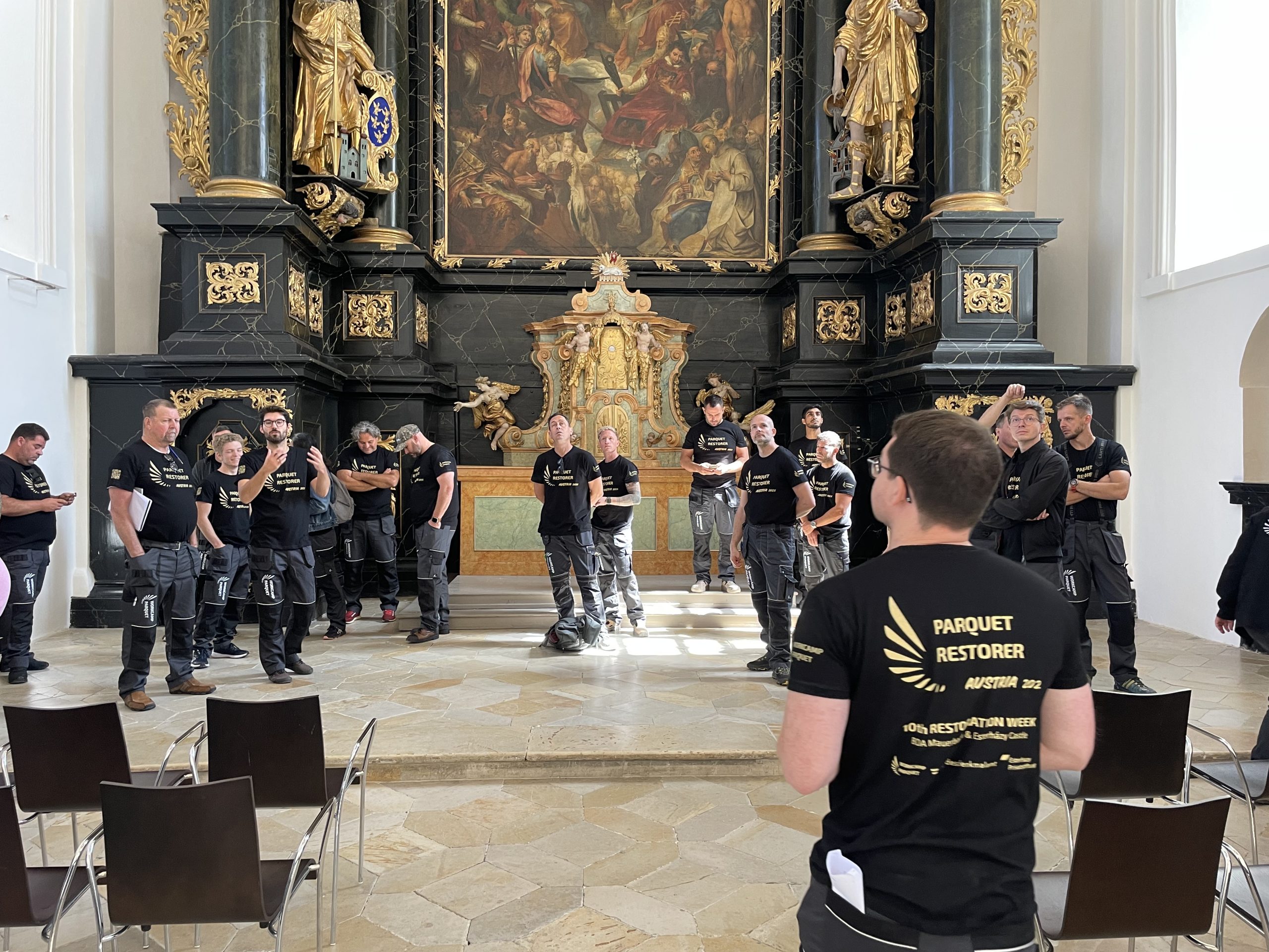 Restoration team in black uniforms gathered in ornate historic interior
