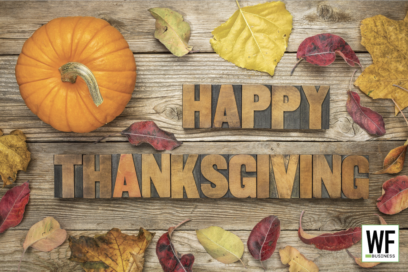 Autumn Thanksgiving scene with orange pumpkin and fall leaves on wooden background