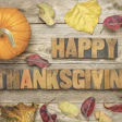 Autumn Thanksgiving scene with orange pumpkin and fall leaves on wooden background