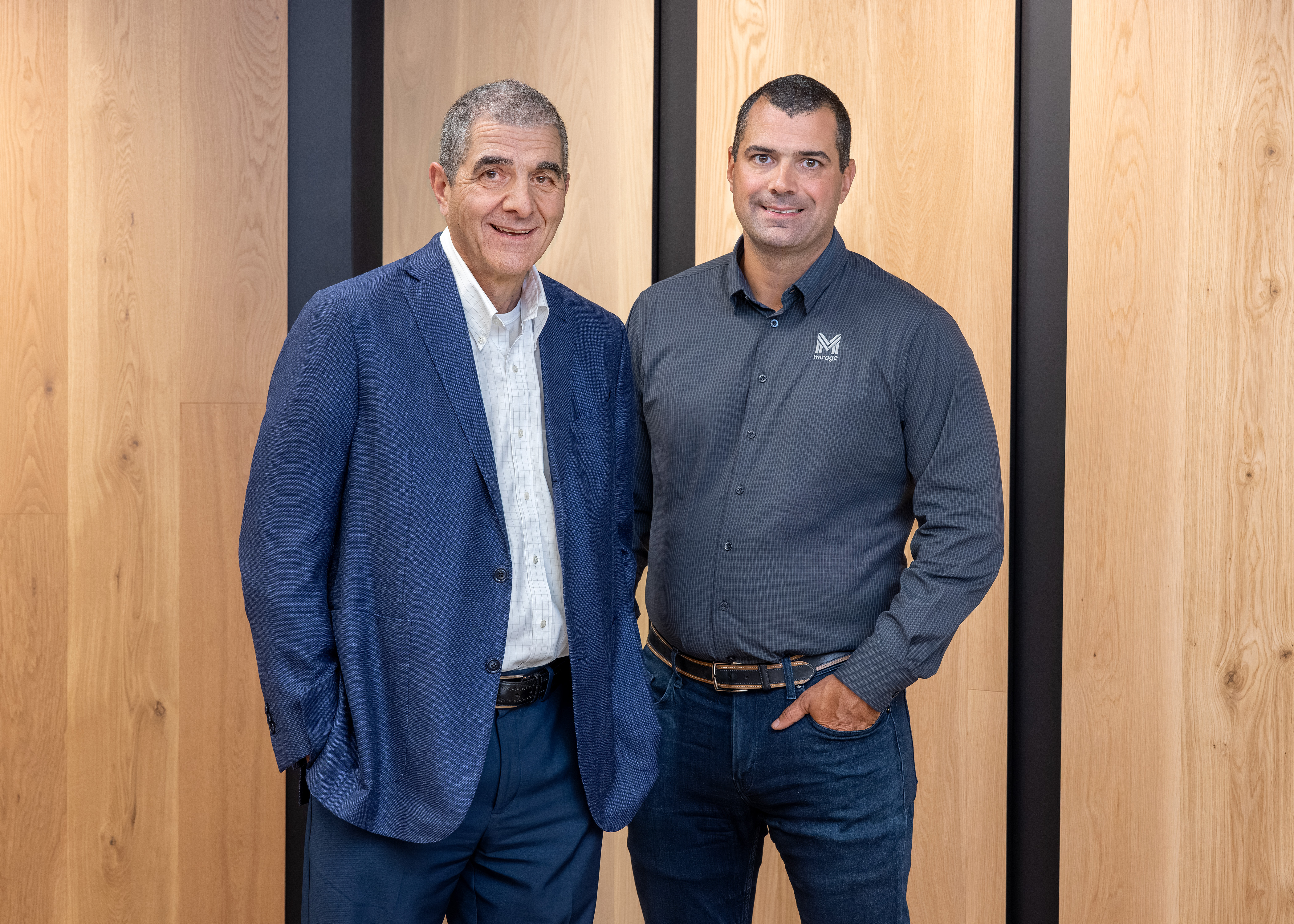 Two professional men in blue and gray business attire standing together