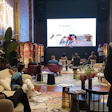 Corporate presentation room with exposed brick walls, projection screen, and attendees