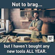 Woodworker in workshop wearing apron, surrounded by woodworking tools and materials