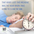 Person sleeping in bed with alarm clock showing daylight saving time, captioned about lost cleaning time