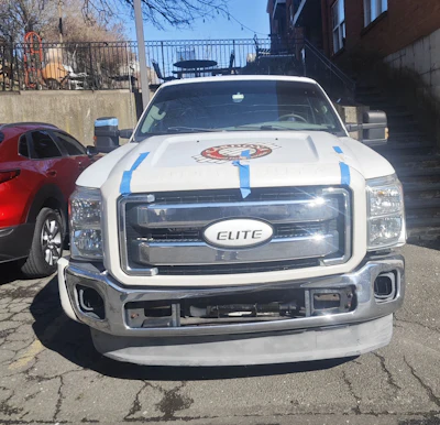 Cardona's truck is a 2011 Ford Super Duty in the front, a 2005 Ford Excursion in the back, and stuffed to the brim with flooring equipment in the middle.