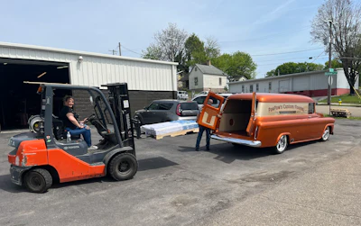 Hall's daughter loading flooring into the truck. The restored Chevy is still used to make deliveries.