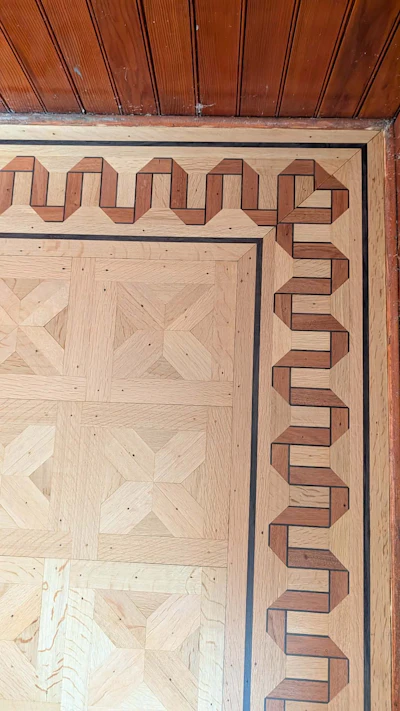 Ornate wooden door with geometric parquet inlay and decorative border trim