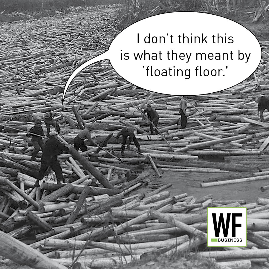 Historical black and white photograph of workers on felled logs with humorous speech bubble about floating floor construction