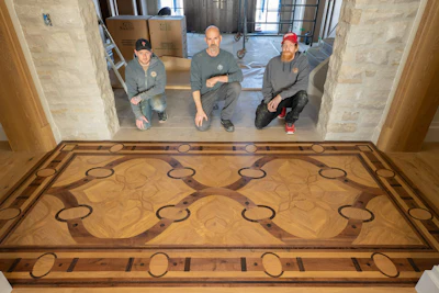 He and his team worked long hours to complete this floor and move onto the next; but Vivash (at center) says it was worth it for his floor to be the homeowner's favorite design element.