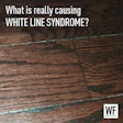 Hardwood floor with white lines between planks and WF Business logo