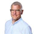 Professional headshot of middle-aged man wearing light blue pinstriped shirt and glasses