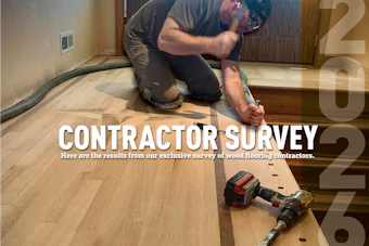 Wood flooring contractor kneeling while installing hardwood flooring with power tools on a residential floor